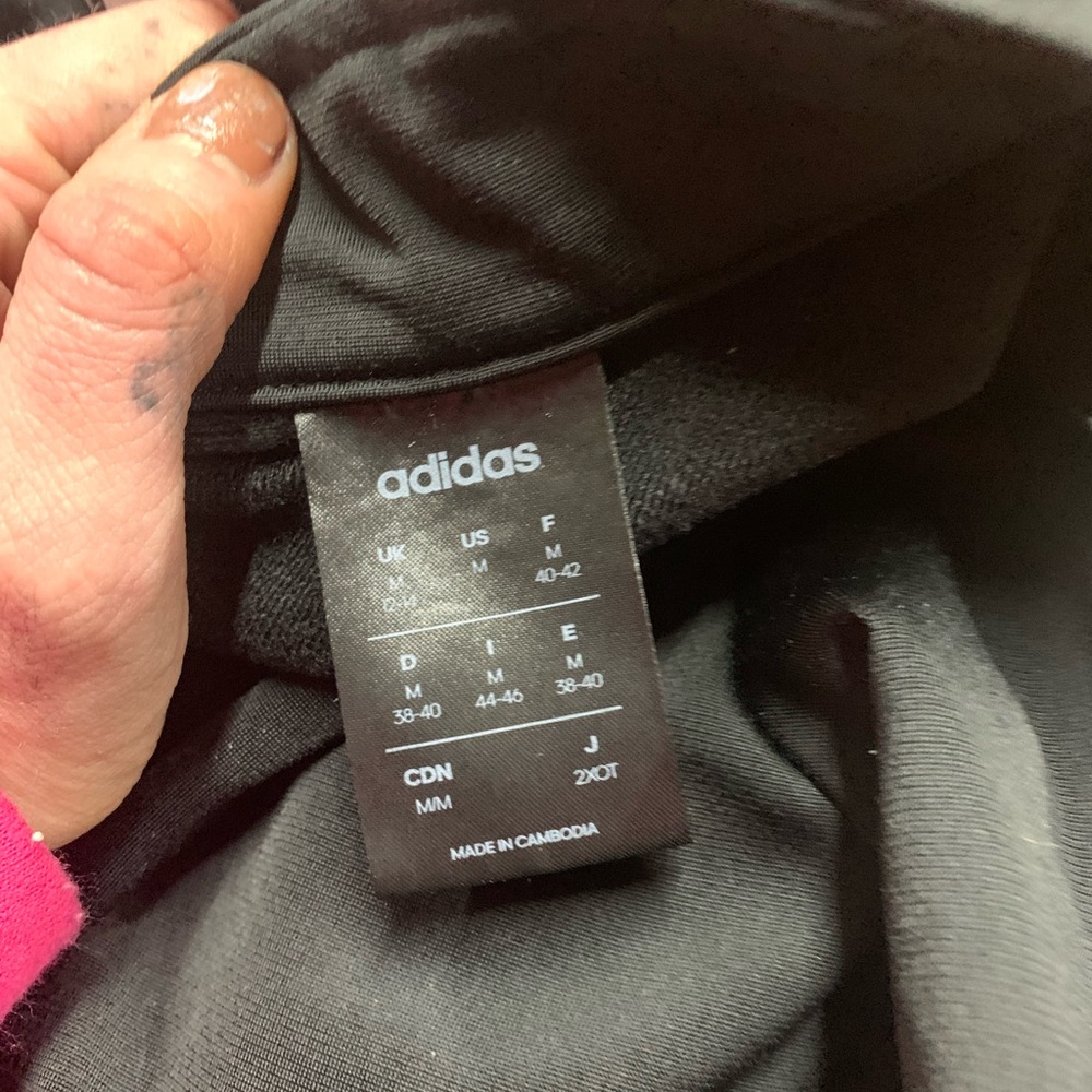 A black zip up hoodless adidas jacket